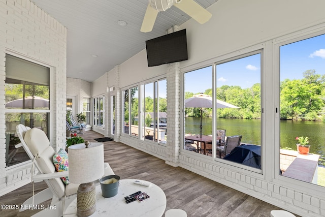 sunroom / solarium featuring high vaulted ceiling, a healthy amount of sunlight, wood finished floors, and ceiling fan