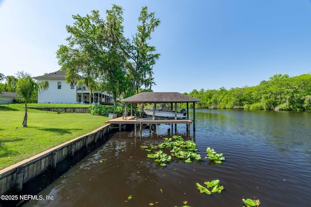 dock area with a water view, boat lift, and a lawn