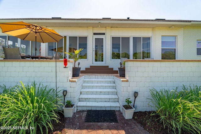 doorway to property with brick siding