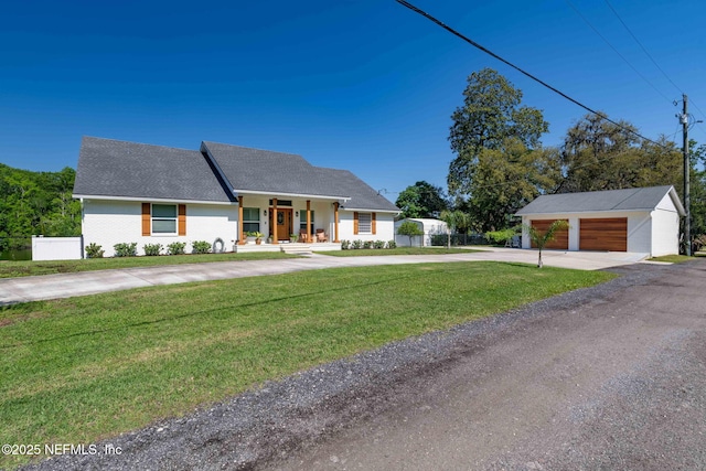 view of front facade featuring concrete driveway, an outdoor structure, a front lawn, fence, and covered porch