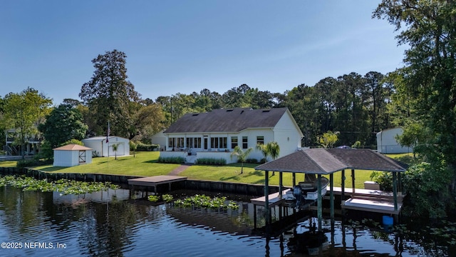 dock area with a water view, a yard, and boat lift
