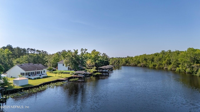 water view featuring a forest view and a dock
