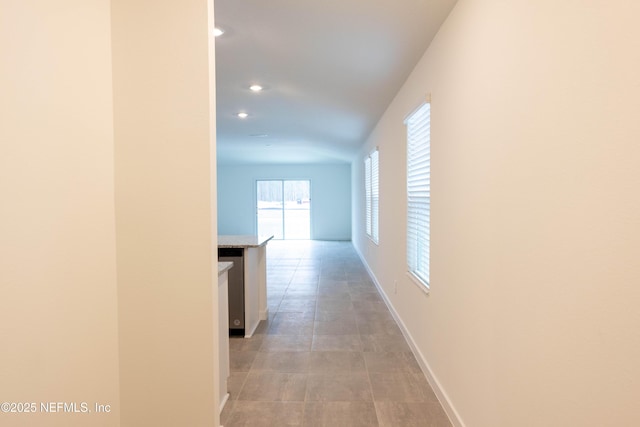 hall featuring baseboards and recessed lighting