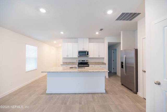kitchen featuring white cabinetry, visible vents, light stone counters, a sink, and stainless steel appliances