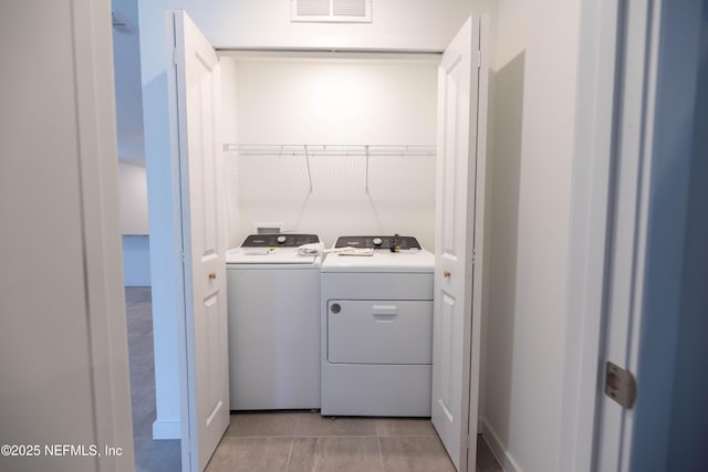 laundry area featuring light tile patterned floors, separate washer and dryer, laundry area, and visible vents