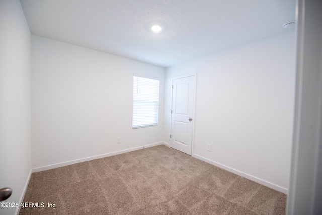 carpeted empty room with baseboards