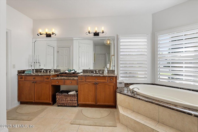 full bath featuring a bath, a chandelier, a sink, tile patterned floors, and double vanity