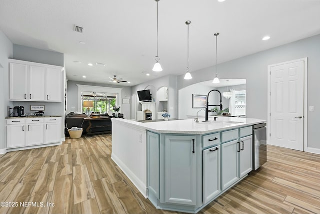 105 Weathered Oak Ct, Saint Johns, FL 32259 - kitchen with dishwasher, light wood-style floors, white cabinets, a kitchen island with sink, and open floor plan