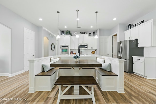 105 Weathered Oak Ct, Saint Johns, FL 32259 - kitchen featuring stainless steel appliances, an island with sink, light wood-style floors, white cabinetry, and recessed lighting
