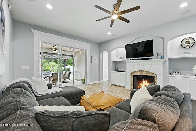 105 Weathered Oak Ct, Saint Johns, FL 32259 - living area with a ceiling fan, arched walkways, light wood finished floors, recessed lighting, and a glass covered fireplace