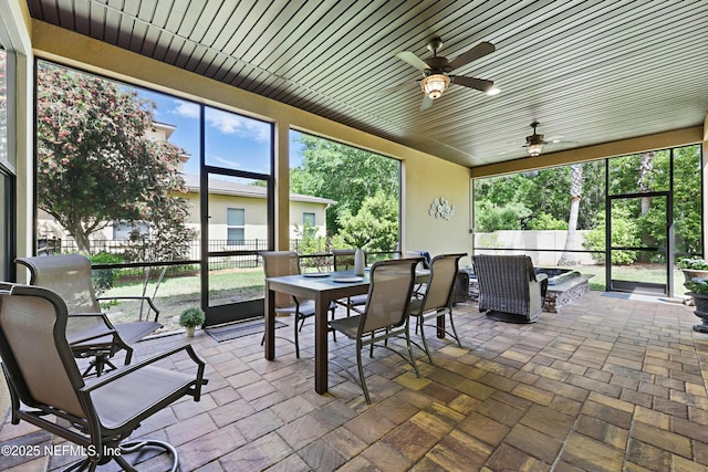 sunroom with ceiling fan and outdoor dining area
