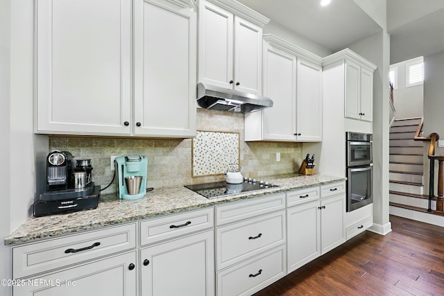 kitchen featuring tasteful backsplash, dark wood-style flooring, white cabinets, under cabinet range hood, and black electric cooktop