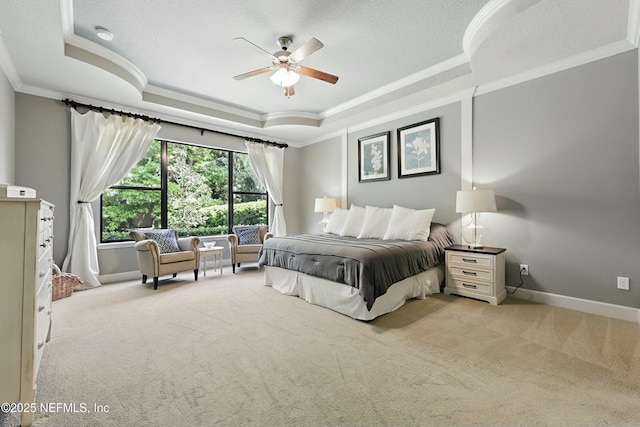 carpeted bedroom featuring baseboards, ornamental molding, and a raised ceiling