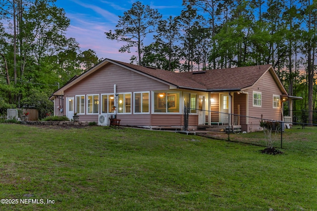 4864 County Road 218, Middleburg, FL 32068 - back of house at dusk with a shingled roof, fence, a lawn, and ac unit