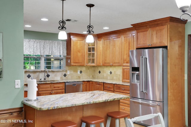 4864 County Road 218, Middleburg, FL 32068 - kitchen featuring glass insert cabinets, a sink, hanging light fixtures, stainless steel appliances, and backsplash