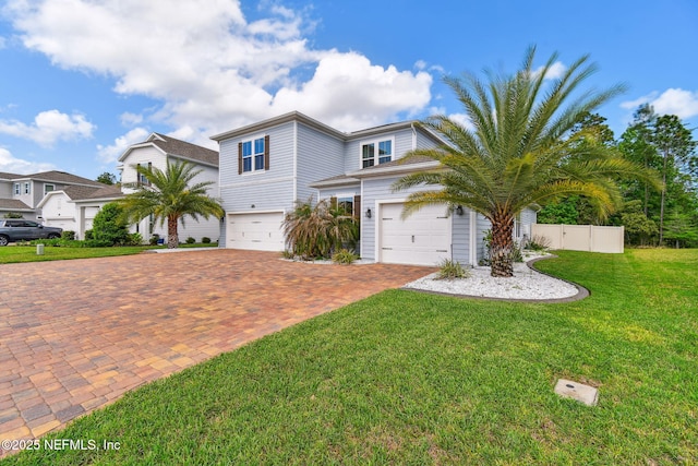 view of front of house with a front yard, fence, a garage, and decorative driveway