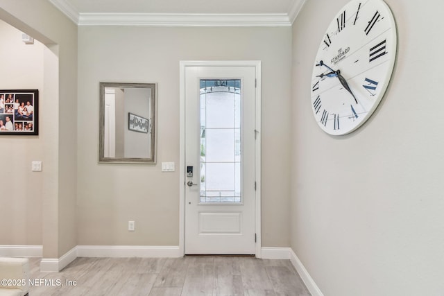 foyer with light wood-style floors, baseboards, and ornamental molding