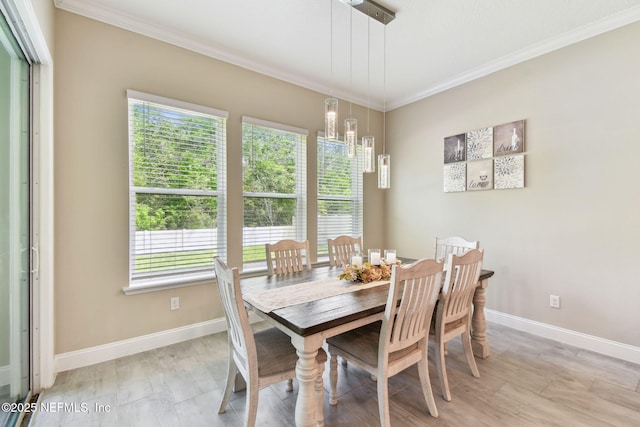 dining room featuring a chandelier, crown molding, baseboards, and a wealth of natural light