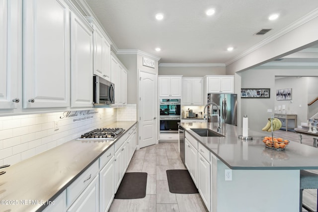 kitchen with white cabinetry, crown molding, visible vents, appliances with stainless steel finishes, and a sink