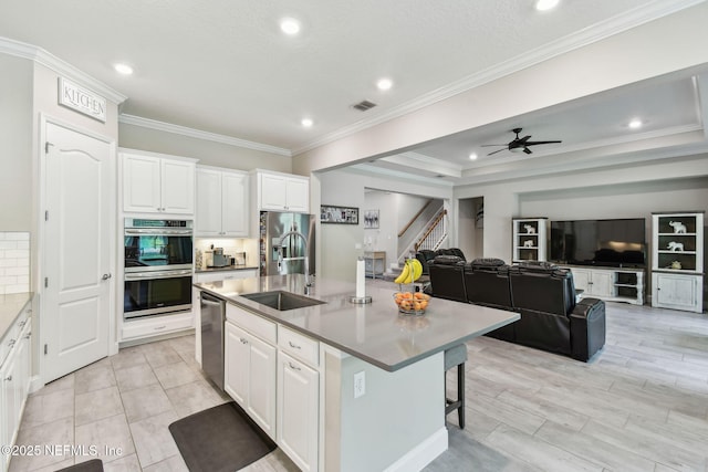 kitchen featuring an island with sink, white cabinetry, visible vents, appliances with stainless steel finishes, and open floor plan