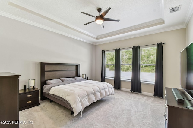 bedroom featuring a tray ceiling, light colored carpet, ornamental molding, and visible vents