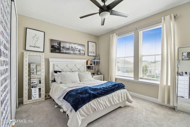 carpeted bedroom with baseboards, a ceiling fan, and a textured ceiling