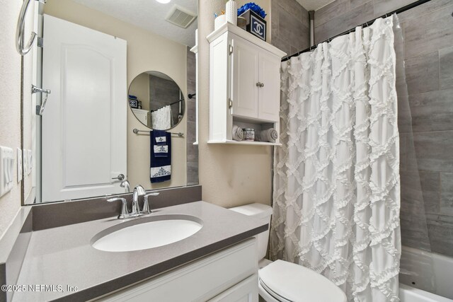 full bathroom with visible vents, toilet, shower / tub combo, and vanity