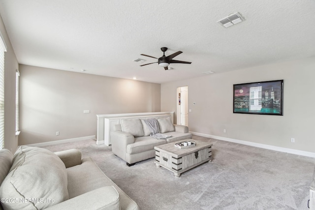living room featuring light colored carpet, ceiling fan, baseboards, and visible vents