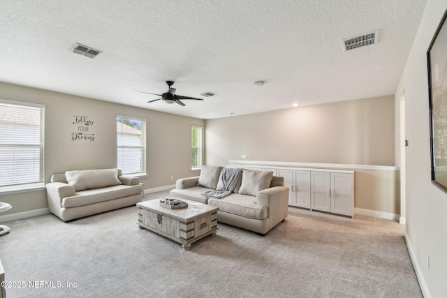 living room with ceiling fan, baseboards, carpet, and visible vents