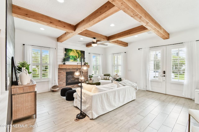 258 Haas Ave, Saint Augustine, FL 32095 - living area with healthy amount of natural light, beamed ceiling, a brick fireplace, french doors, and light wood-type flooring