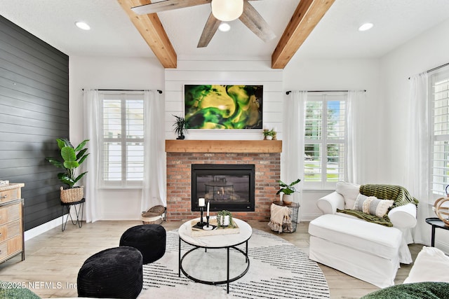 258 Haas Ave, Saint Augustine, FL 32095 - living room with healthy amount of natural light, beamed ceiling, light wood-style flooring, a ceiling fan, and a fireplace