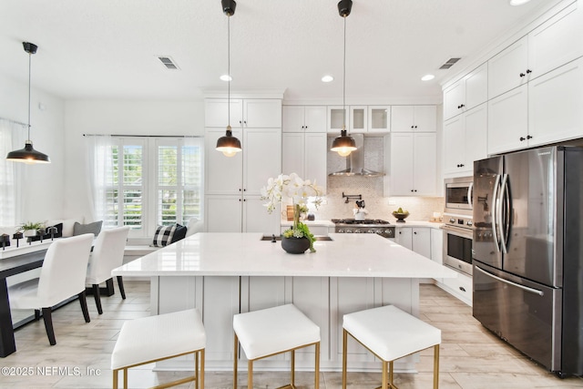 258 Haas Ave, Saint Augustine, FL 32095 - kitchen with stainless steel appliances, wall chimney exhaust hood, recessed lighting, light countertops, and white cabinets