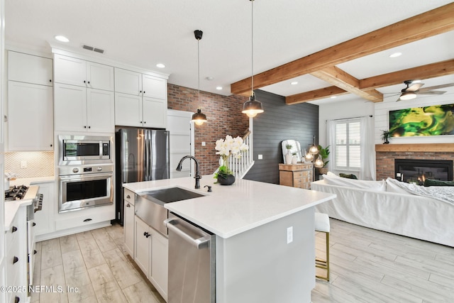 258 Haas Ave, Saint Augustine, FL 32095 - kitchen featuring appliances with stainless steel finishes, a sink, open floor plan, light wood-type flooring, and beam ceiling