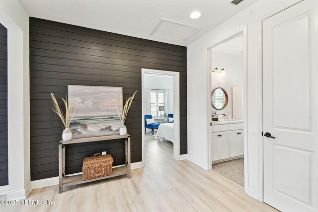 258 Haas Ave, Saint Augustine, FL 32095 - hallway featuring light wood finished floors, attic access, baseboards, and wood walls