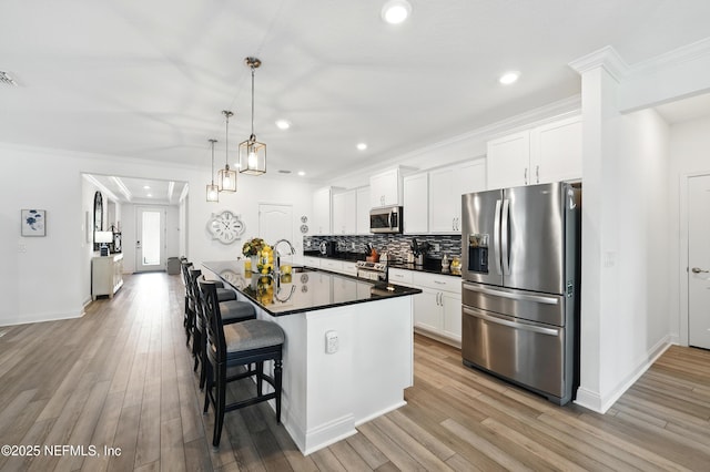 3313 Loofah Pl, Green Cove Springs, FL 32043 - kitchen featuring a kitchen breakfast bar, white cabinetry, appliances with stainless steel finishes, dark countertops, and light wood finished floors