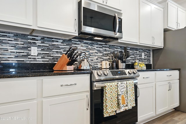 3313 Loofah Pl, Green Cove Springs, FL 32043 - kitchen with appliances with stainless steel finishes, white cabinetry, light wood-style flooring, and backsplash