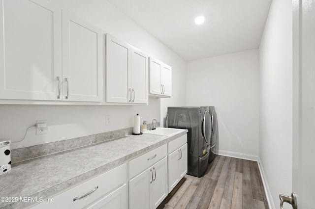 3313 Loofah Pl, Green Cove Springs, FL 32043 - laundry area with a sink, baseboards, washer and dryer, light wood-type flooring, and cabinet space