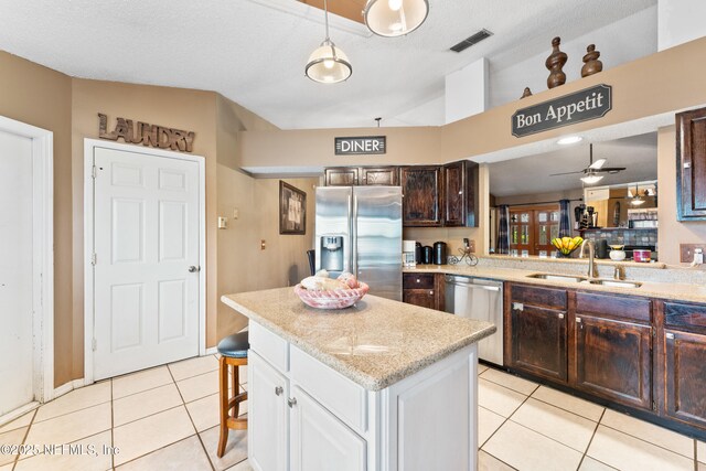 9083 Sable Ridge Ct, Jacksonville, FL 32244 - kitchen featuring dark brown cabinetry, light tile patterned flooring, visible vents, stainless steel appliances, and a sink