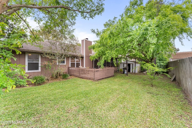 9083 Sable Ridge Ct, Jacksonville, FL 32244 - back of property with an outdoor structure, a chimney, a shed, a fenced backyard, and a lawn