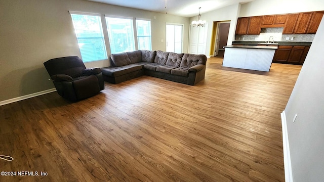11775 Blueberry Ln, Macclenny, FL 32063 - living area with light wood-style flooring, an inviting chandelier, baseboards, and lofted ceiling