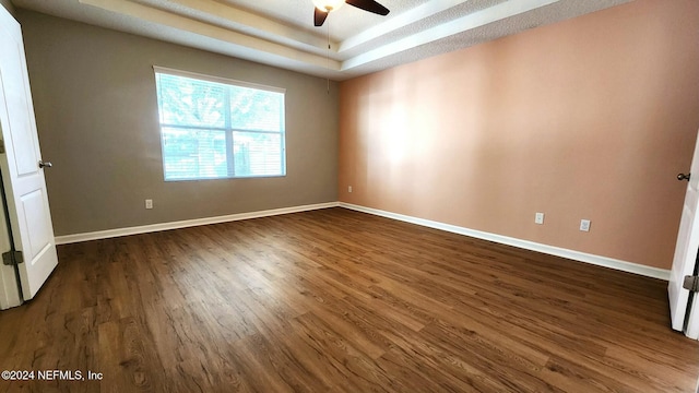 11775 Blueberry Ln, Macclenny, FL 32063 - empty room with dark wood-type flooring, a tray ceiling, baseboards, and a ceiling fan