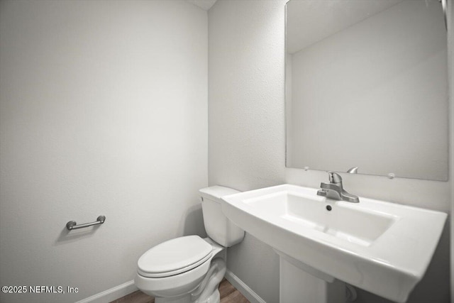 8922 Free Ave, Jacksonville, FL 32211 - half bathroom with a sink, toilet, wood finished floors, and baseboards