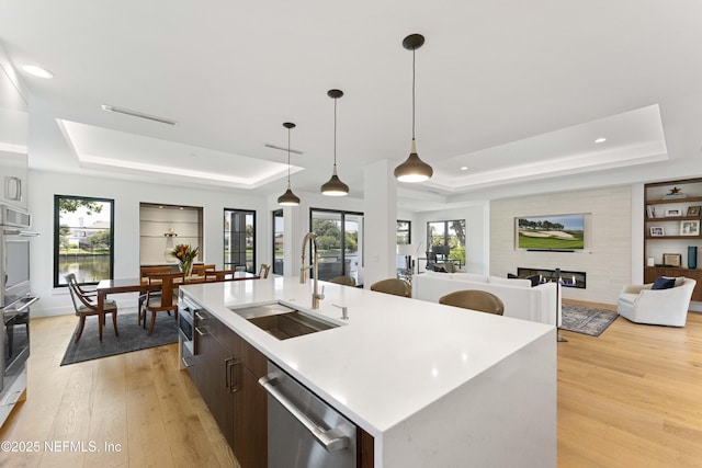 1592 Harbour Club Dr, Ponte Vedra Beach, FL 32082 - kitchen with light wood-type flooring, a large fireplace, a raised ceiling, appliances with stainless steel finishes, and a sink