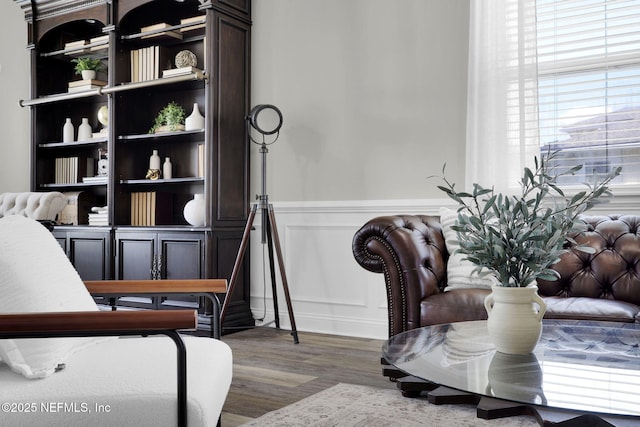 sitting room featuring wood finished floors and a wainscoted wall