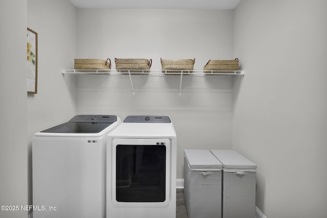 laundry room with washer and clothes dryer, laundry area, baseboards, and wood finished floors