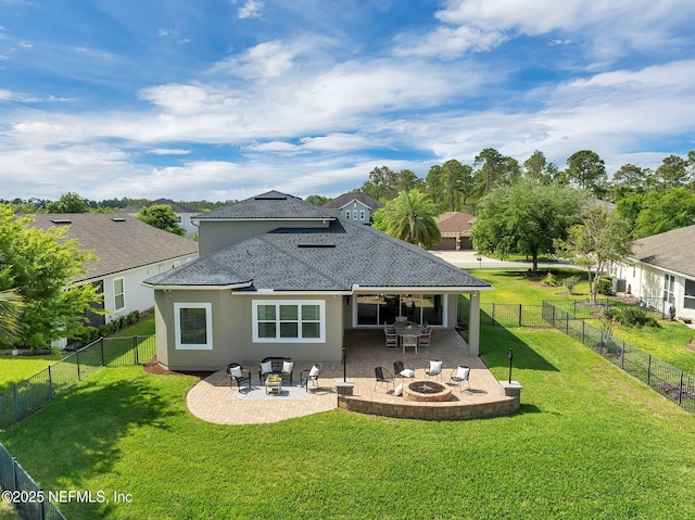 back of property with a patio area, a fire pit, a fenced backyard, and a lawn