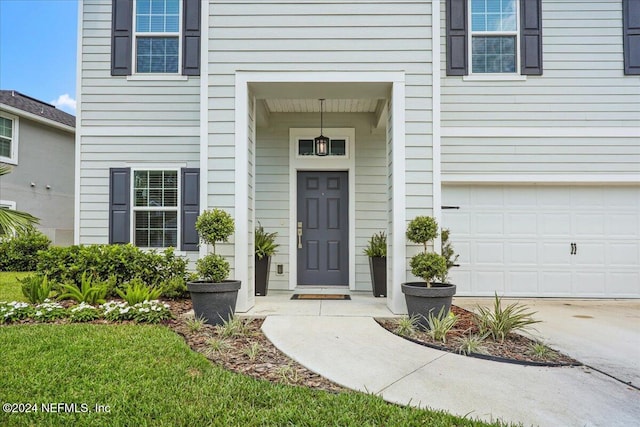 property entrance with an attached garage and concrete driveway