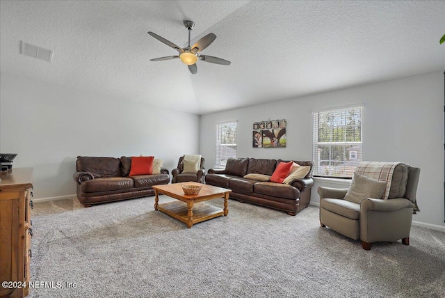 living area with visible vents, a ceiling fan, carpet, and a wealth of natural light