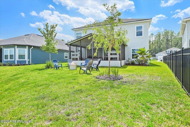 rear view of house featuring fence, a yard, and a sunroom
