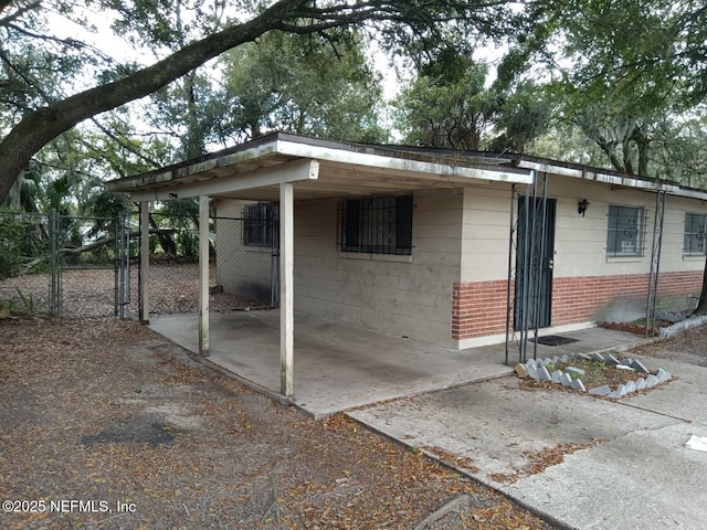 6450 San Juan Ave, Jacksonville, FL 32210 - view of outbuilding with concrete driveway, fence, a gate, and an attached carport